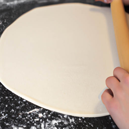 A close-up of pizza dough being rolledout into a thin crust.